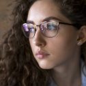 Young woman with curly hair in eyeglasses